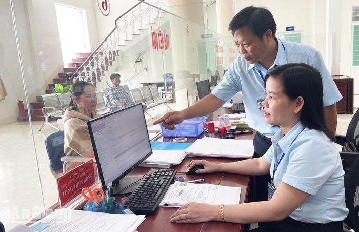 Phó Giám đốc Trung tâm Phục vụ hành chính công xã Vĩnh Hòa Hưng Lâm Hồng Khải cùng đồng nghiệp ứng dụng trợ lý ảo pháp luật nâng cao hiệu quả giải quyết thủ tục hành chính cho người dân. Ảnh: CẨM TÚ