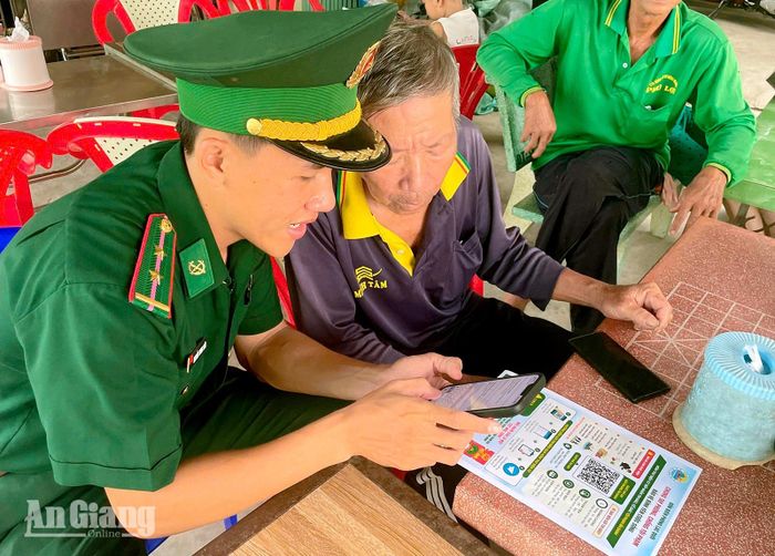 Cán bộ Đồn Biên phòng Lạc Quới hướng dẫn người dân sử dụng hòm thư tố giác tội phạm ẩn danh. Ảnh: Hoàng Thanh
