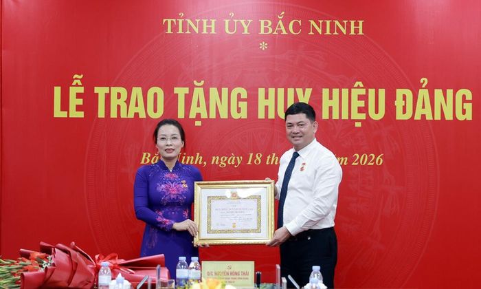  Đồng chí Bí thư Tỉnh ủy Nguyễn Hồng Thái trao tặng Huy hiệu Đảng cho đồng chí Nguyễn Thị Hương. 