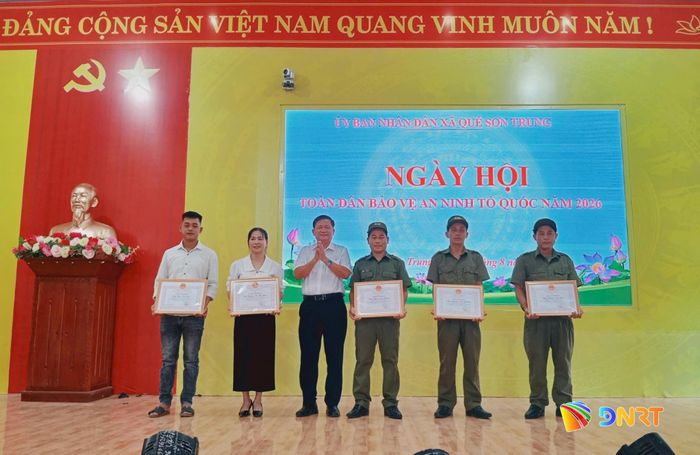 Ông Ngô Văn Nhanh, Chủ tịch UBND xã Quế Sơn Trung trao giấy khen cho các cá nhân có thành tích xuất sắc trong thực hiện phong trào "Toàn dân bảo vệ an ninh Tổ quốc". Ảnh: DUY THÁI