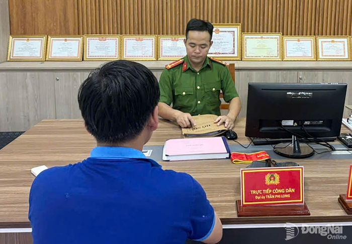 Cán bộ Đồn Công an Khu công nghiệp Biên Hòa làm việc với đối tượng tham gia đánh bạc trên không gian mạng. Ảnh: C.T.V