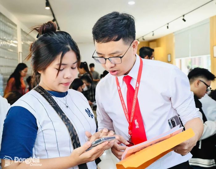 Cán bộ tuyển sinh hướng dẫn tân sinh viên quy trình nhập học. Ảnh: Công Nghĩa