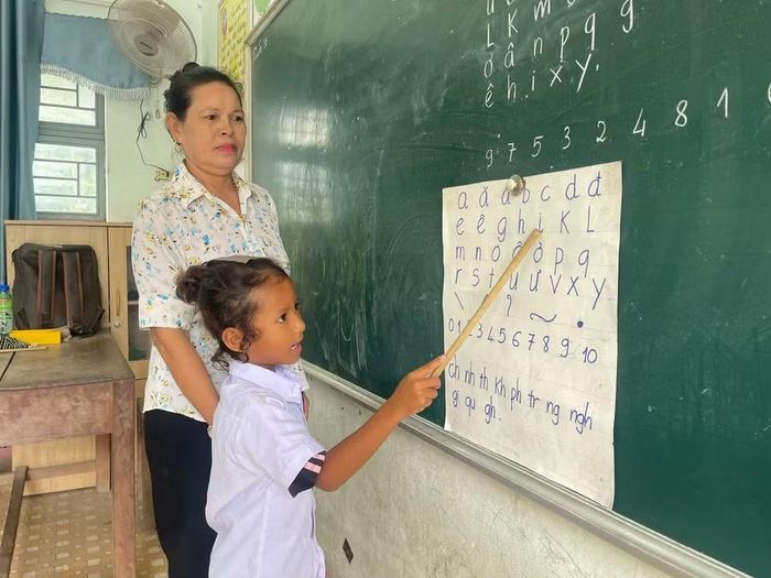 Giáo viên Trường Tiểu học và THCS Nay Der hướng dẫn học sinh đọc bảng chữ cái, chữ số. Ảnh: Vũ Chi