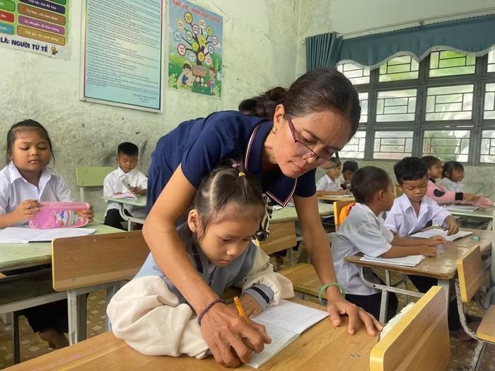 Cô giáo Ksor H’Gôn, giáo viên Trường Tiểu học và THCS Nay Der hướng dẫn học sinh cách viết các nét cơ bản. Ảnh: Vũ Chi