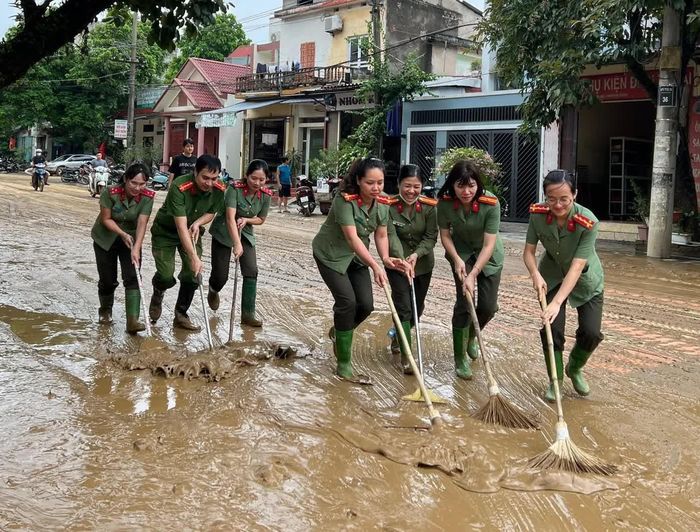 Lực lượng Công an nhân dân cùng nhau dọn bùn khi cơn lũ đi qua, giúp người dân khắc phục hậu quả thiên tai.