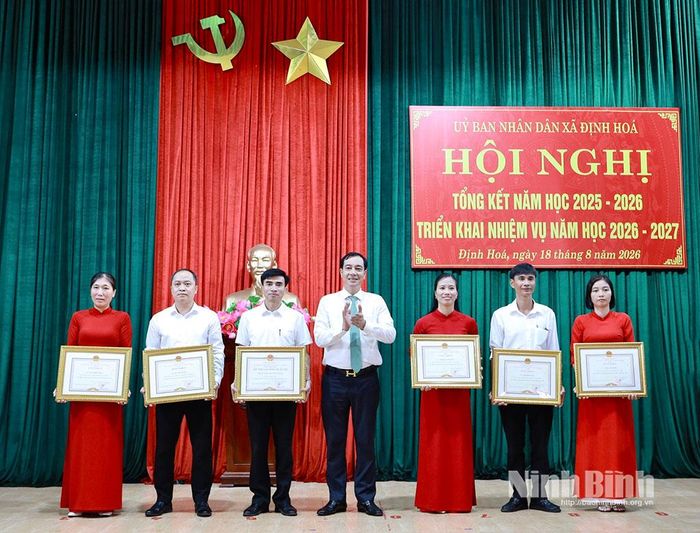 Thừa ủy quyền, lãnh đạo xã Định Hoá trao danh hiệu “Tập thể lao động xuất sắc”; Bằng khen của Chủ tịch UBND tỉnh cho các tập thể, cá nhân có thành tích xuất sắc trong năm học 2025-2026. Ảnh: Lan Anh