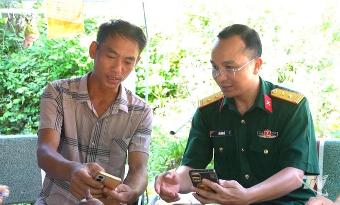 Cán bộ Ban CHQS xã Dân Tiến hướng dẫn người dân nhận diện, phòng tránh thông tin xấu độc trên mạng xã hội.