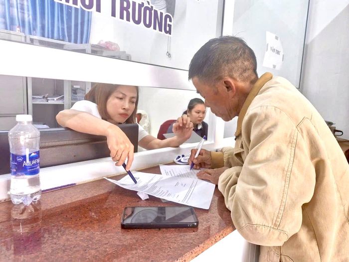 Cán bộ Trung tâm phục vụ hành chính công hỗ trợ người dân trong quá trình làm thủ tục.