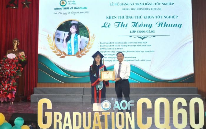 TS. Nguyễn Văn Bình - Phó Giám đốc Học viện Tài chính trao Giấy khen của Giám đốc Học viện cho Thủ khoa Lê Thị Hồng Nhung tại Lễ bế giảng. Ảnh: Đức Việt