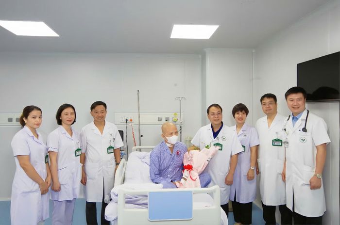 Giám đốc Bệnh viện 19-8 Nguyễn Tiến Quang và các bác sĩ tặng hoa chúc mừng bệnh nhân xuất viện.