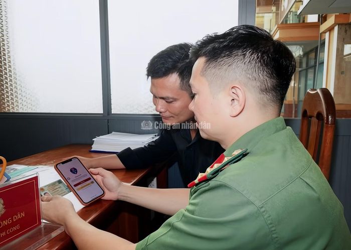 Khi người dân đến làm thủ tục hành chính, Công an cơ sở hướng dẫn tra cứu “phạt nguội” qua ứng dụng VNeTraffic.