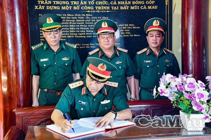 Thượng tướng Phùng Sĩ Tấn ghi sổ lưu niệm sau khi dâng hương. 