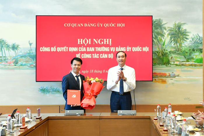 Đồng chí Phùng Khánh Tài trao Quyết định và tặng hoa chúc mừng tân Phó Trưởng Ban Tổ chức Đảng ủy Quốc hội Bùi Danh Tuyên. Ảnh: M. Thúy