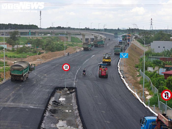 Hàng loạt xe ben, máy rải, xe lu và máy đào liên tục vận chuyển vật liệu, thi công mặt đường, đường dẫn và các nhánh kết nối tại nút giao. 