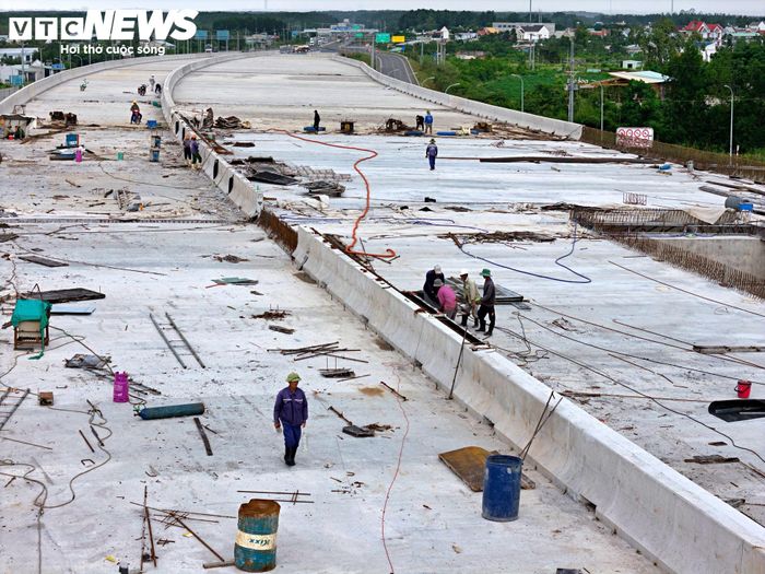 Trên mặt cầu, công nhân đang hoàn thiện dải phân cách, khe co giãn và vệ sinh mặt cầu, chuẩn bị cho các công đoạn cuối.