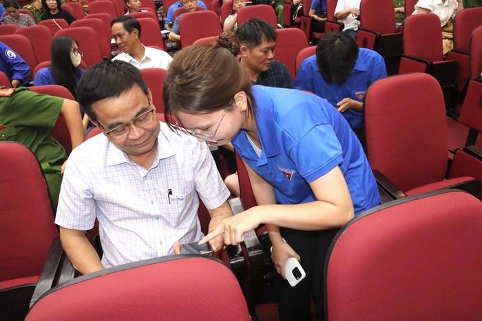 Đoàn viên thanh niên phường Từ Liêm hướng dẫn người dân chuyển đổi số. Ảnh: PV