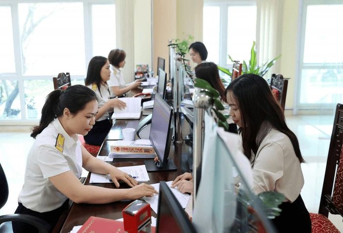 Công chức thuế hướng dẫn người nộp thuế thực hiện quyết toán thuế thu nhập cá nhân. Ảnh: Đức Thanh
