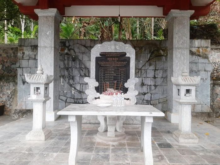 Tên tuổi 11 dân công hỏa tuyến được khắc ghi tại nhà bia tưởng niệm trước cửa Hang Co Phương. Ảnh: Ngọc Hưng.