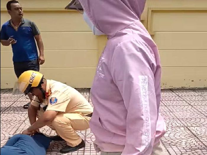 Trung tá Nguyễn Đức Thành thực hiện sơ cứu tại chỗ khi chị Tô Thị Thủy bị đột quỵ. Ảnh: Cơ quan Công an.