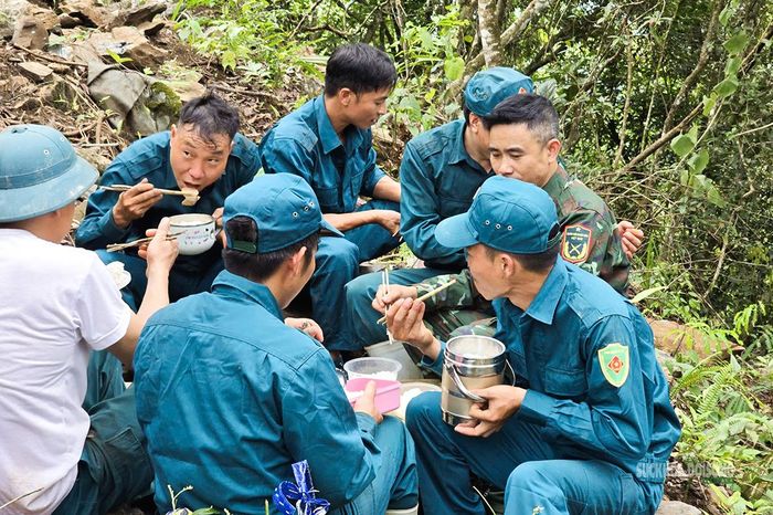 Bữa cơm trưa giữa rừng của dân quân và cán bộ, chiến sĩ làm nhiệm vụ tìm kiếm. Ảnh: Tuấn Anh
