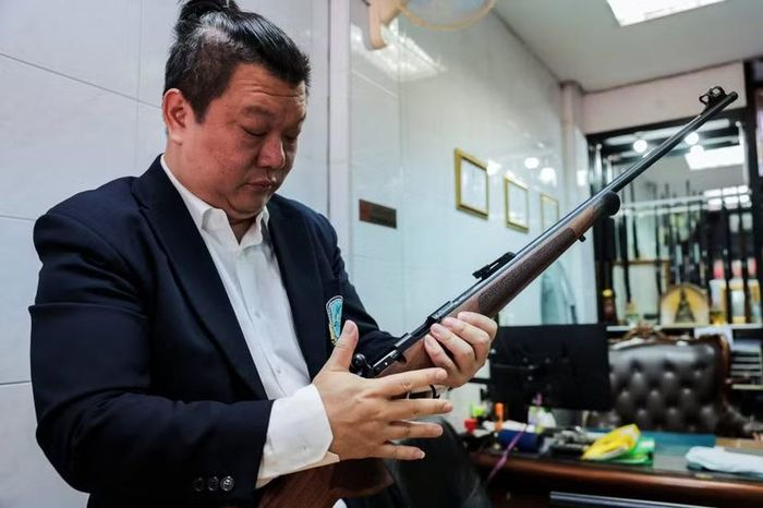Ông Thititorn Bupparamanee, Chủ tịch Hiệp hội Kinh doanh vũ khí Thái Lan, kiểm tra một khẩu súng trường tại một cửa hàng ở khu phố buôn bán súng lâu đời của Bangkok ngày 15-8-2026