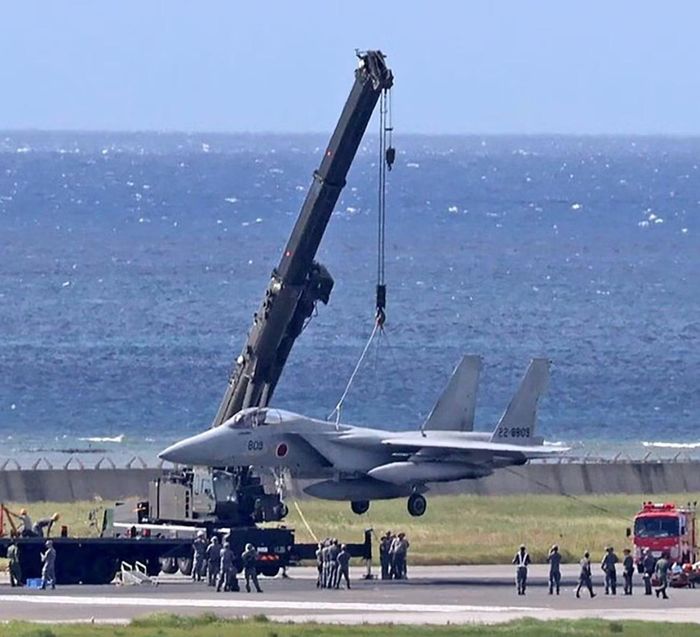 Cần cẩu đưa chiếc F-15J gặp sự cố khỏi đường băng ở sân bay Naha, tỉnh Okinawa, Nhật Bản ngày 18/8.