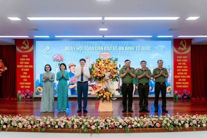 Đại tá Nguyễn Tiến Đạt - Ủy viên Ban thường vụ Đảng ủy, Phó Giám đốc CATP Hà Nội tặng hoa chúc mừng Ngày hội tại Bệnh viện Nhi Hà Nội