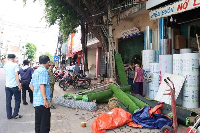 Lực lượng chức năng nhắc nhở các hộ kinh doanh không lấn chiếm lòng đường, vỉa hè