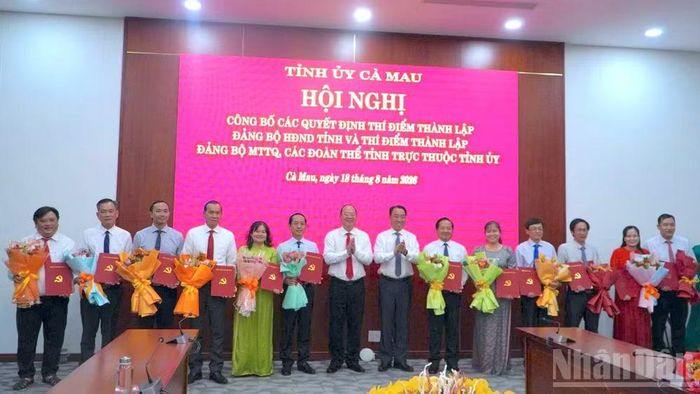 Bí thư Tỉnh ủy Cà Mau Nguyễn Hồ Hải cùng Phó Bí thư Tỉnh ủy, Chủ tịch Ủy ban nhân dân tỉnh Lữ Quang Ngời (đứng giữa) trao quyết định và tặng hoa các đồng chí được chỉ định tham gia Ban Chấp hành, Ban Thường vụ, giữ chức Bí thư, Phó Bí thư Đảng ủy Mặt trận Tổ quốc, các đoàn thể tỉnh Cà Mau. (Ảnh: HỮU TÙNG)