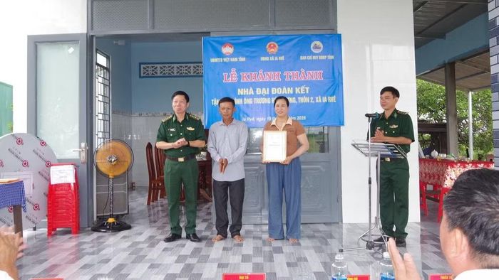 Đại tá Đỗ Quang Thấm, Phó Chính ủy Bộ Chỉ huy quân sự tỉnh Đắk Lắk kiêm Chính ủy Ban Chỉ huy Bộ đội Biên phòng tỉnh, trao biểu trưng “Nhà Đại đoàn kết” cho gia đình ông Trương Hữu Lương. (Ảnh: DÂN QUÂN)
