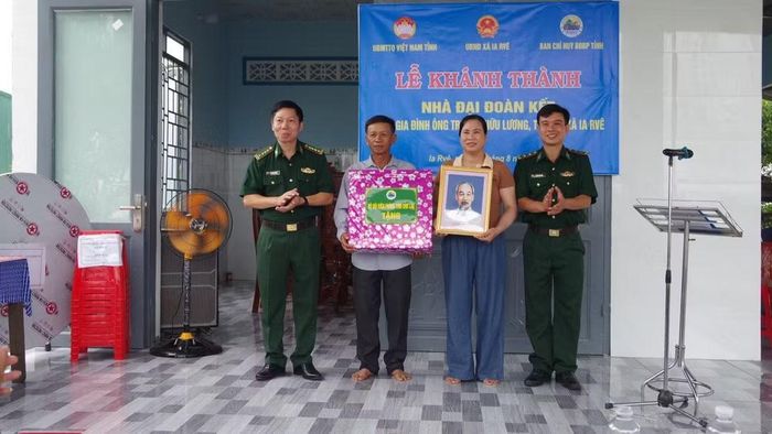 Đại tá Đỗ Quang Thấm, Phó Chính ủy Bộ Chỉ huy quân sự tỉnh Đắk Lắk kiêm Chính ủy Ban Chỉ huy Bộ đội Biên phòng tỉnh, tặng quà gia đình ông Trương Hữu Lương. (Ảnh: DÂN QUÂN)