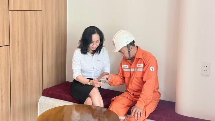 Cán bộ ngành điện tư vấn về ứng dụng EVN CSKH cho khách hàng. (Ảnh: LÊ CHI)
