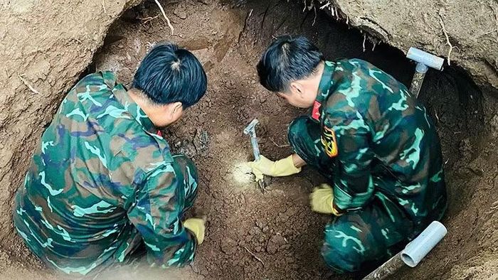 Lực lượng làm nhiệm vụ cẩn thận tìm hài cốt liệt sĩ. (Ảnh: NHƯ ANH)