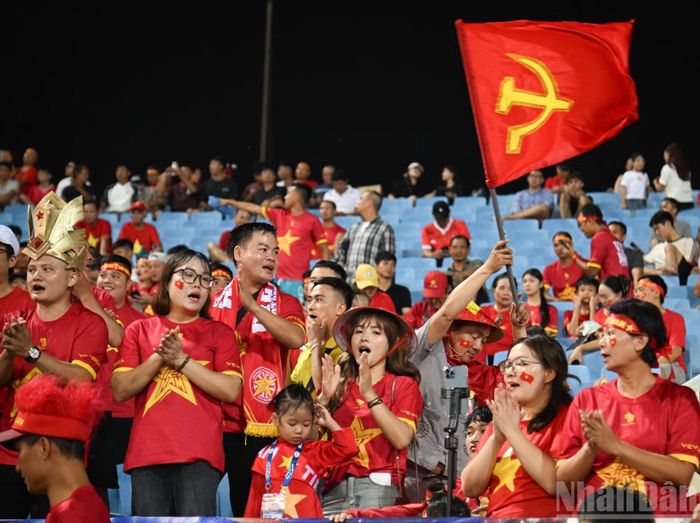 Những cổ động viên trẻ hòa vào dòng người đến sân, tạo nên bầu không khí rộn ràng trước trận đấu.