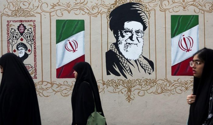 Người dân đi ngang qua bức tranh tường vẽ cố Lãnh tụ Tối cao Iran Ayatollah Ali Khamenei trên một con phố ở Tehran, Iran. Ảnh: AP