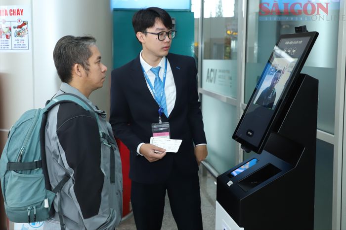 Nhân viên sân bay Liên Khương hướng dẫn người dân làm thủ tục sinh trắc học. Ảnh: ĐOÀN KIÊN