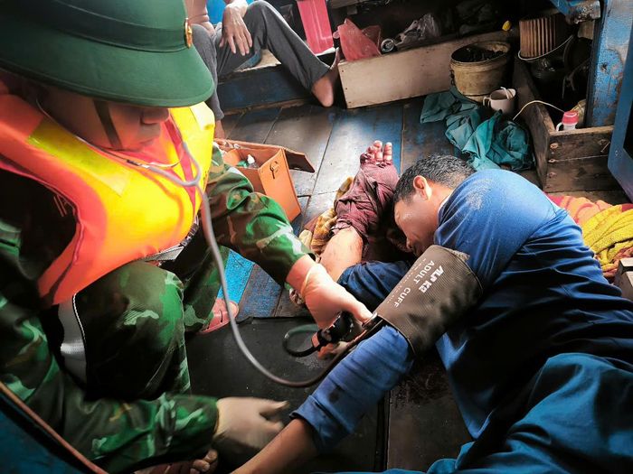 Cán bộ quân y Đồn Biên phòng Nhật Lệ đang tiến hành sơ cứu cho ngư dân bị nạn. Ảnh: ANH QUÂN