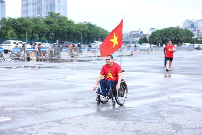  Dù thời tiết không thuận lợi nhưng vẫn không ngăn được niềm đam mê bóng đá của 1 cổ động viên khuyết tật. Ảnh: TIẾN CƯỜNG 