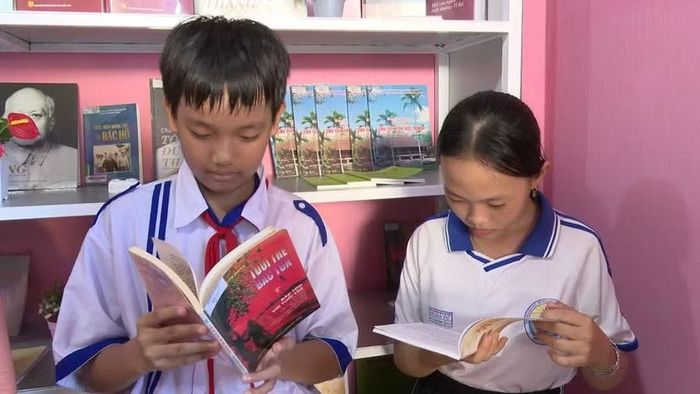 Lãnh đạo địa phương, người dân và học sinh tham quan, đọc sách sau lễ ra mắt thư viện.
