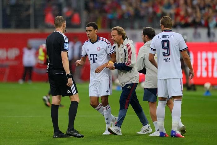 Chỉ 4 ngày sau, cảnh tượng tương tự lại xuất hiện trong trận Bayern Munich thắng FC Heidenheim 4-2. Tiền vệ Musiala được tung vào sân từ ghế dự bị nhưng chỉ thi đấu khoảng 8 phút trước khi một lần nữa gục xuống, khiến trận đấu phải tạm dừng để đội ngũ y tế vào sân chăm sóc. Ảnh: The Sun.