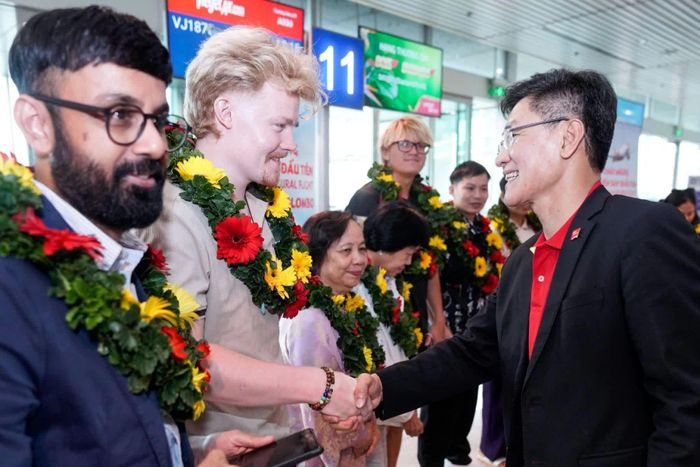Lãnh đạo hãng hàng không Vietjet tặng hoa và chào đón hành khách trên chuyến bay đầu tiên. (Nguồn: VGP)