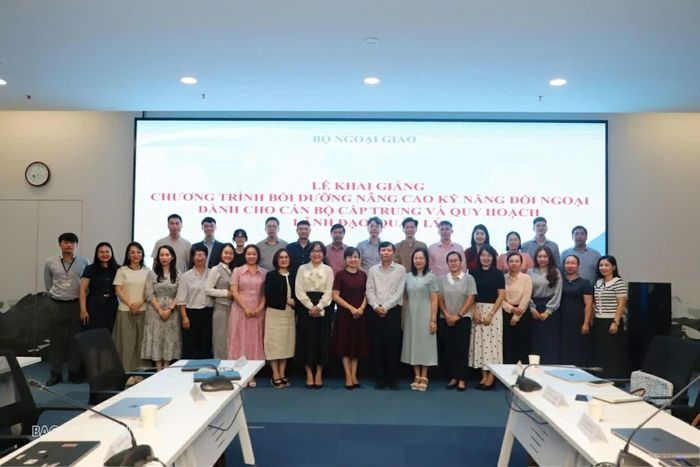 Các học viên tham gia khoá học chụp ảnh lưu niệm cùng PGS.TS. Đại sứ Đặng Đình Quý, đại diện Vụ Tổ chức Cán bộ và đại diện Ban Đào tạo, bồi dưỡng cán bộ đối ngoại, Học viện Ngoại giao. (Ảnh: Minh Nhuận)