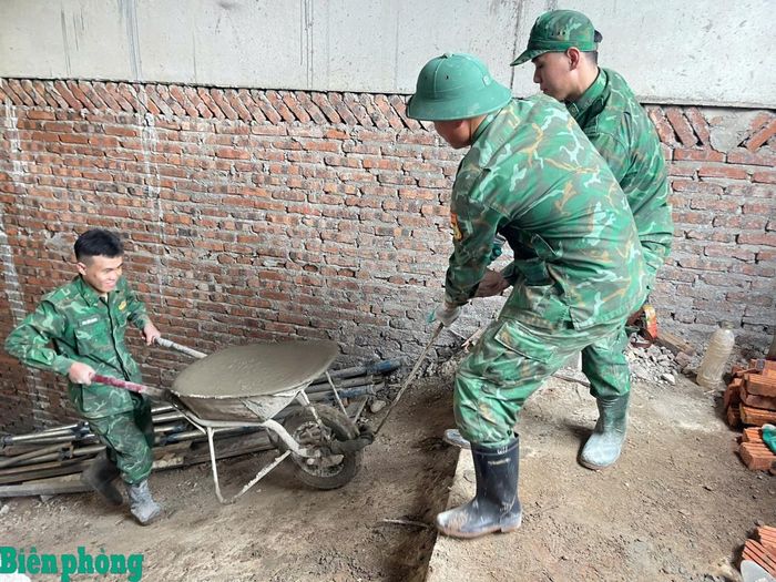 Cán bộ, chiến sĩ Bộ đội Biên phòng tỉnh Nghệ An tham gia vận chuyển vật liệu, hỗ trợ các đơn vị thi công đẩy nhanh tiến độ xây dựng trường phổ thông nội trú liên cấp tại khu vực biên giới. Ảnh: Hải Thượng