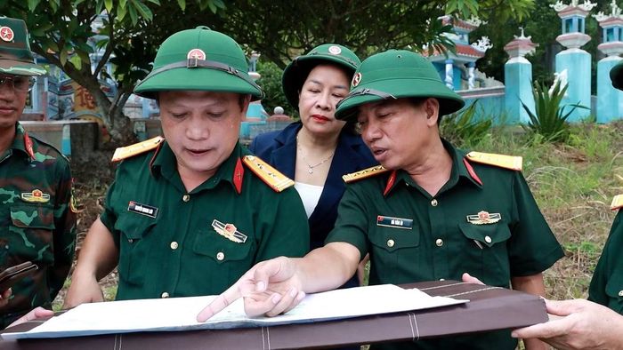 Đại tá Hà Văn Ái (bìa phải) - Phó Chính ủy Bộ CHQS TP. Huế, kiểm tra vị trí trên bản đồ - nơi nghi chôn thi thể các liệt sĩ ở phía bắc đèo Phước Tượng.
