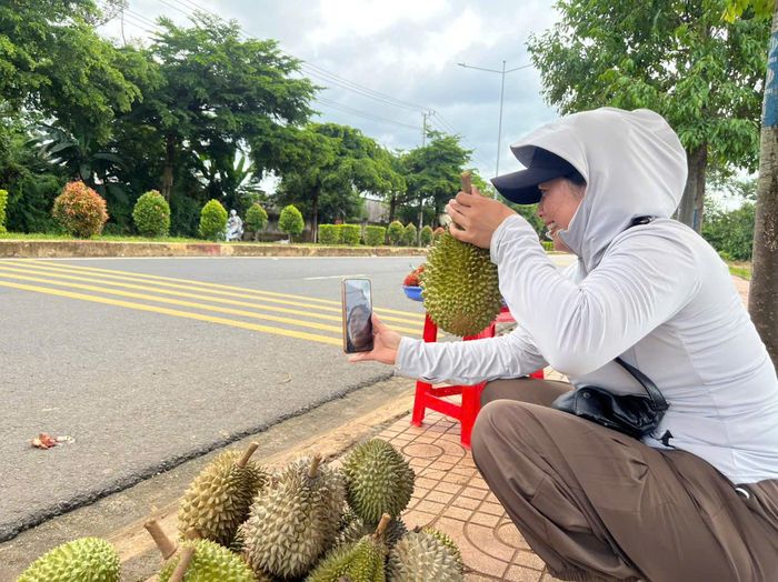 Chị H' Ui Êban giao dịch bán sầu riêng qua điện thoại với khách hàng.
