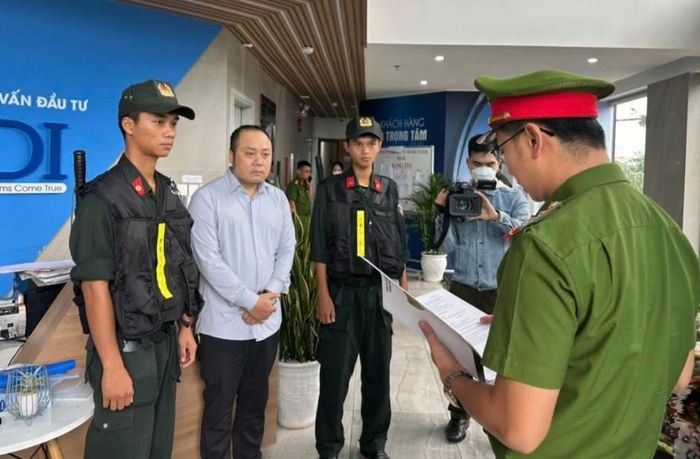 Công an đọc lệnh khởi tố bị can Nguyễn Quang Hoàng (thứ 2 từ trái sang) vào tháng 11/2024. Ảnh: CACC