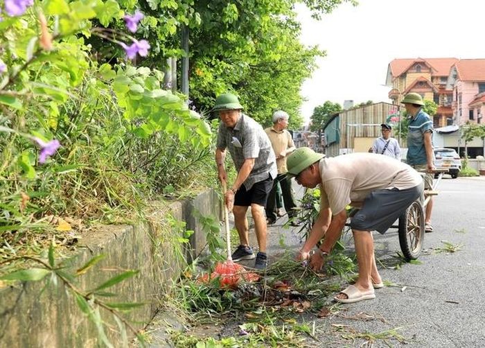  Người dân xã Thư Lâm dọn dẹp vệ sinh môi trường. Ảnh: Quang Thái