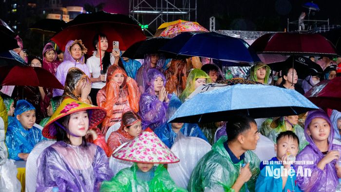 Đông đảo nhân dân đội mưa thưởng thức chương trình nghệ thuật: "Nghệ An - nơi ánh dương bừng sáng". Ảnh: Phạm Bằng