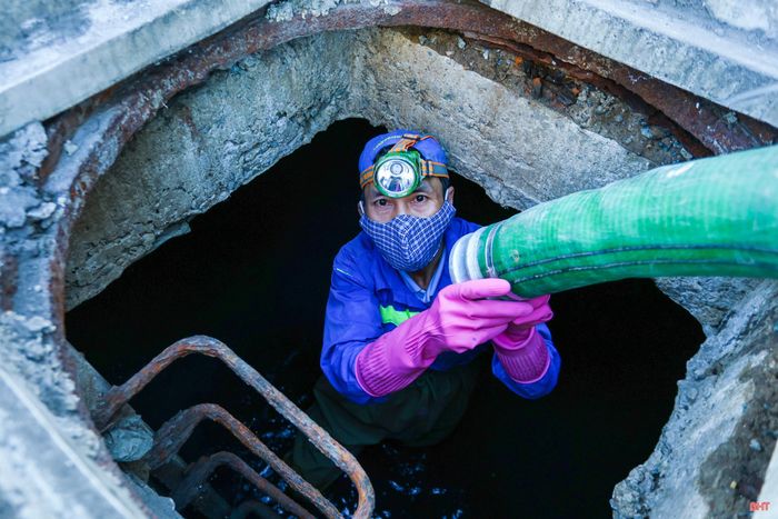 Nhóm công nhân thực hiện các thao tác chuẩn bị để xuống cống ngầm nạo vét bùn.