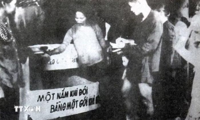 Tháng 11/1945, Trung ương Đảng ra Chỉ thị Kháng chiến, kiến quốc, củng cố chính quyền, chống thực dân Pháp xâm lược, trong đó, về cứu tế, kêu gọi lòng yêu nước thương nòi, lập quỹ cứu tế, lập kho thóc cứu tế, đẩy mạnh khai hoang tăng gia sản xuất, quyên góp tiếp tế cho dân nghèo... Trong ảnh: Phong trào “Hũ gạo cứu đói” với tinh thần “Một nắm khi đói bằng một gói khi no” lan rộng khắp cả nước. (Ảnh: Tư liệu TTXVN)